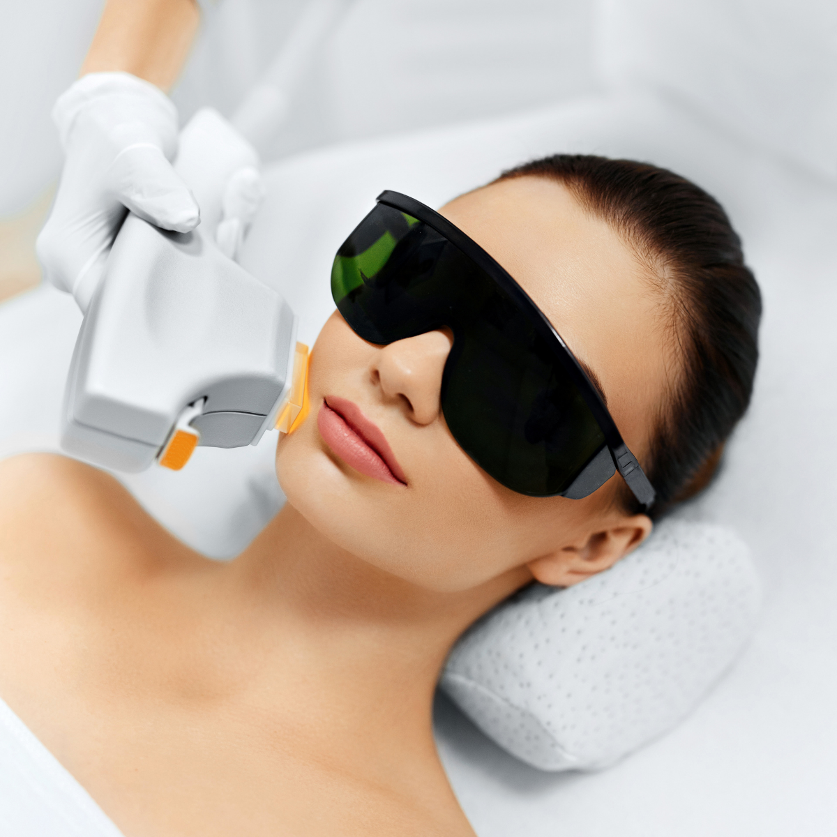Laser hair removal treatment on woman’s face with protective eyewear